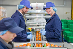 Food manufacturing staff following health and safety procedures on a food production line